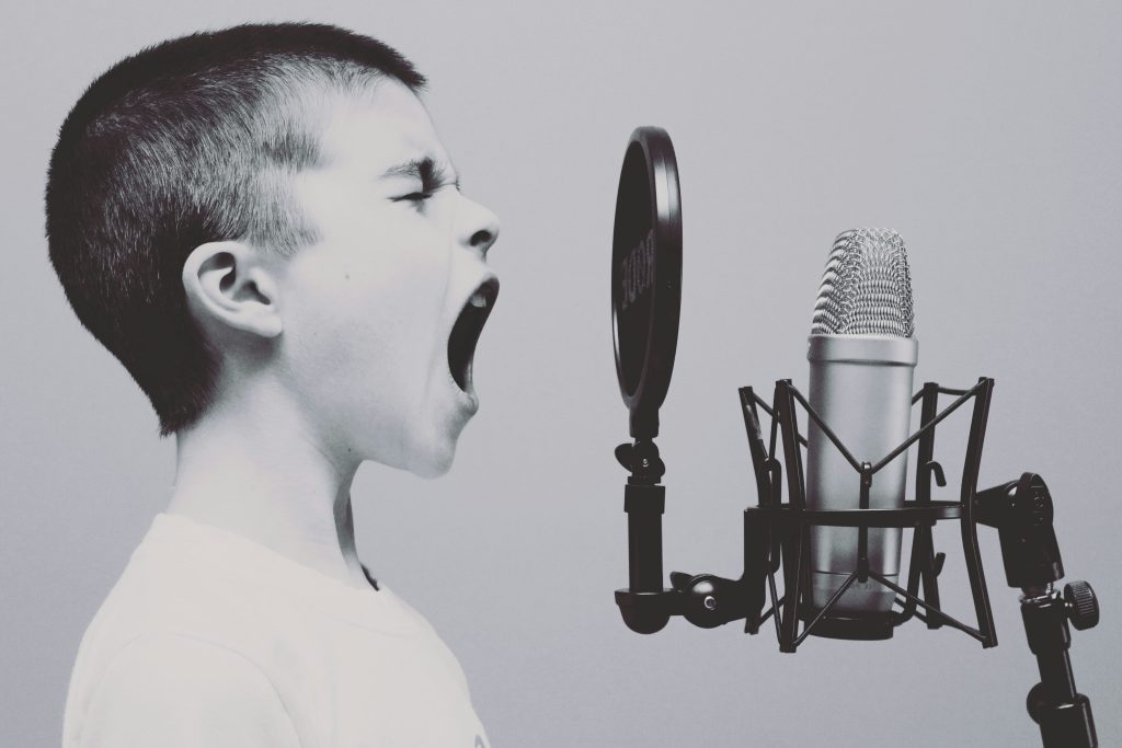 boy singing on microphone with pop filter